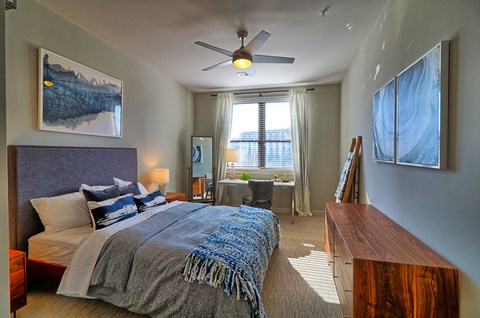 a bedroom with a large bed and a ceiling fan